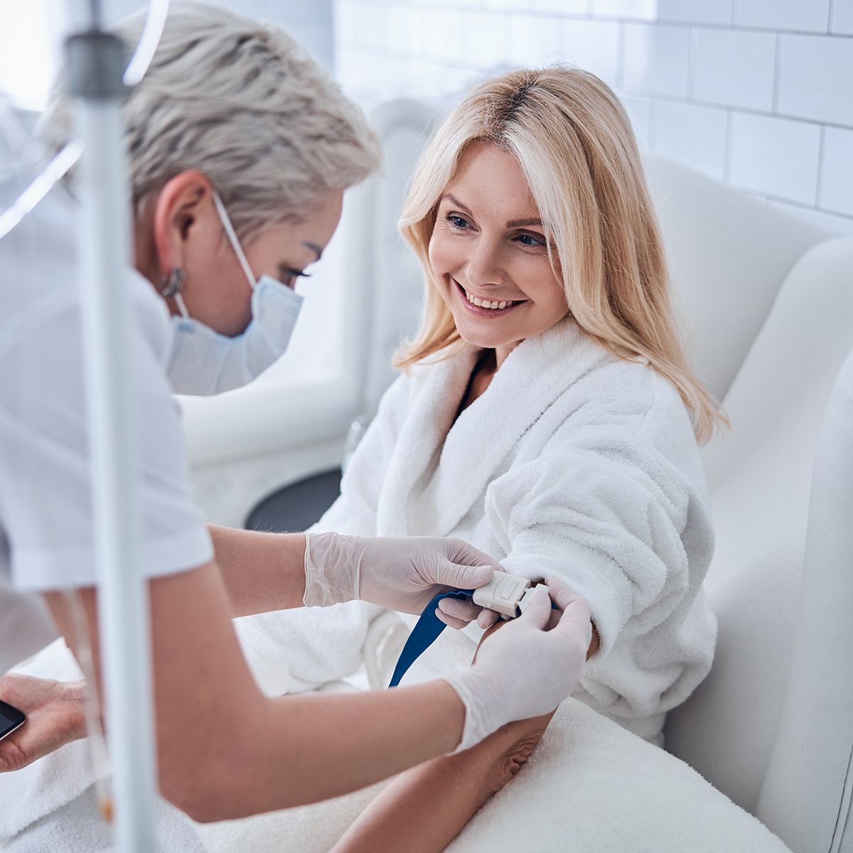 Nurse preparing an IV for a smiling client